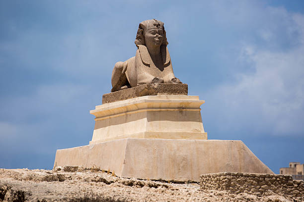 Alexandria, Egypt - July 19, 2016: One of two sphinx positioned by Pompey's Pillar in Alexandria, a monolithic column built in 297 AD, commemorating the victory of Roman emperor Diocletian over an Alexandrian revolt.