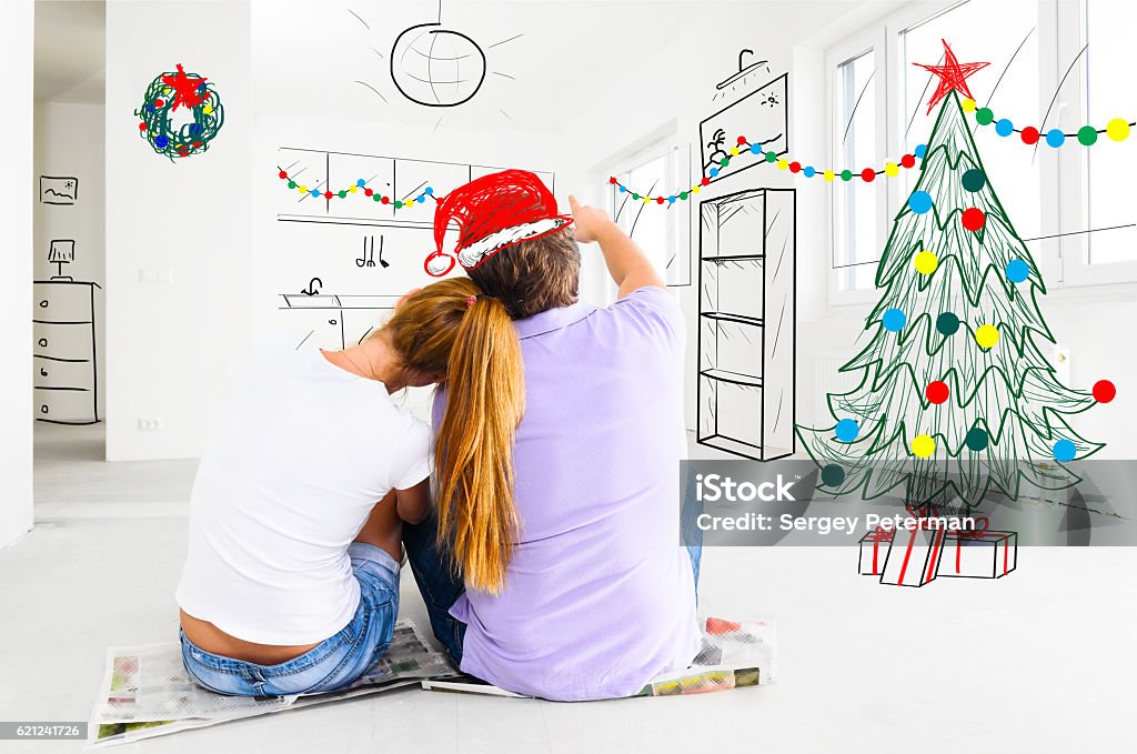 couple planning to decorate new apartment young couple is planning christmas or new year decoration of their new apartments Christmas Stock Photo