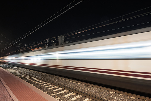 Fast train passing through a station at night ( motion blurred image)