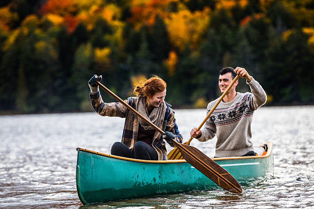 Couple enjoying a ride on a typical canoe in Canada Couple enjoying a ride on a typical canoe in the Algonquin Park, Ontario - Canada. canoeing stock pictures, royalty-free photos & images