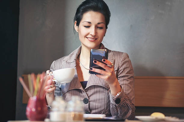 istock Young beautiful businesswoman at coffee break using smart phone 621246198