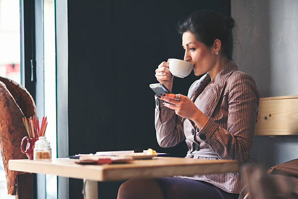 istock Businesswoman having a coffee break and using smart phone 621246394