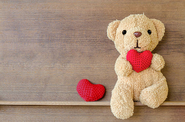istock Teddy bear holding a heart-shaped pillow 621246940