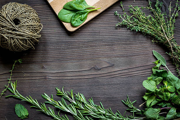 istock fresh herb frame on dark wooden background top view 621248318