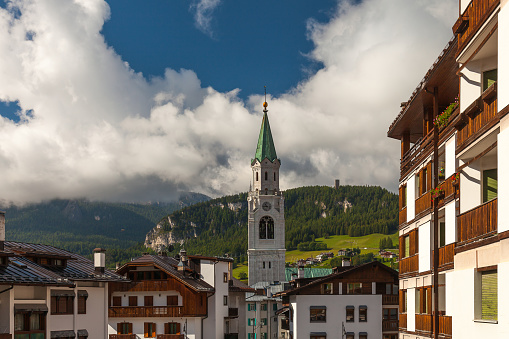 The Church rises above the houses on the background mountains and cloudy sky