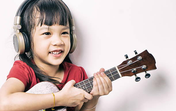 istock Asian girl is practicing guitar and wearing headphone. 621255118