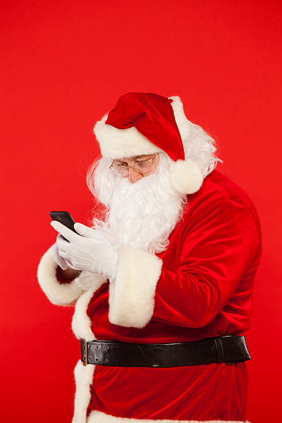 istock Photo of Santa Claus using mobile phone, on a red 621255230