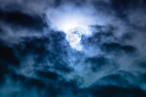 istock Nighttime sky with clouds and bright full moon with shiny. 621255408