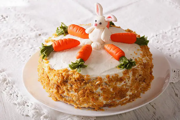 Photo of carrot cake with candy bunny close-up on the table. horizontal