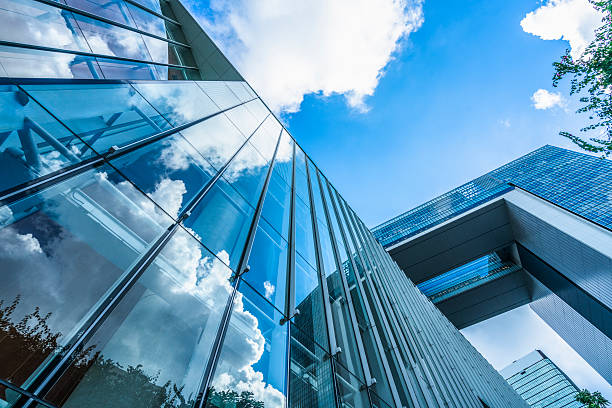 istock blue sky and clouds reflected at glass wall 621261046