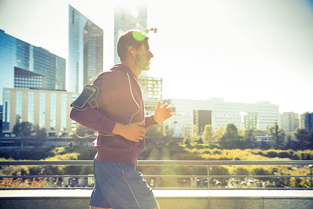 athlete with earphones running in the city stock photo