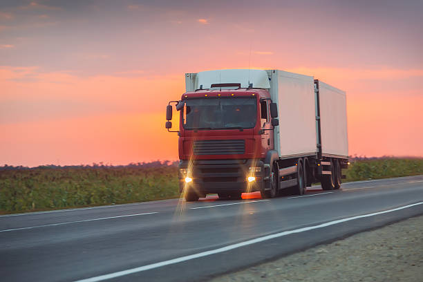 istock truck goes on highway on sunset 621266430
