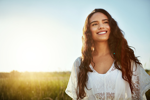 Shot of an attractive young woman standing outside in a field