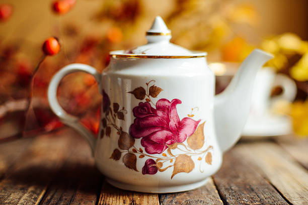 Tea in the rustic Chic style.  Tea Party.  Green tea in a cup and saucer, teapot, sugar bowl, set, tableware for tea. Teapot of healthy herbal tea, dry flowers. Cup of tea with autumn decor on  table.