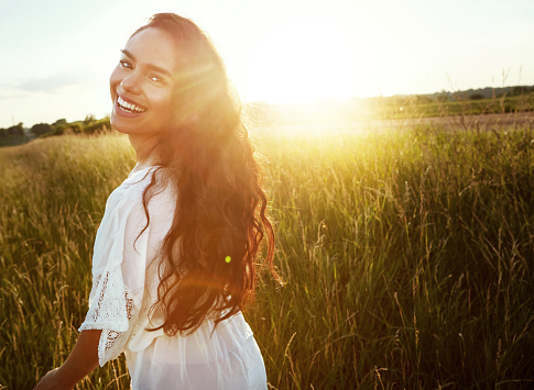 Portrait of an attractive young woman standing outside in a field
