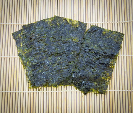 closeup roasted seaweed snack (kim nori) on traditional bamboo mat