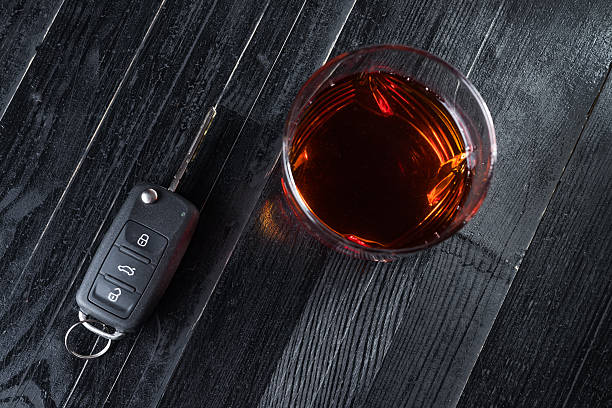 автомобильный ключ и виски в стакане на черном деревянном - designated driver стоковые фото и изображения