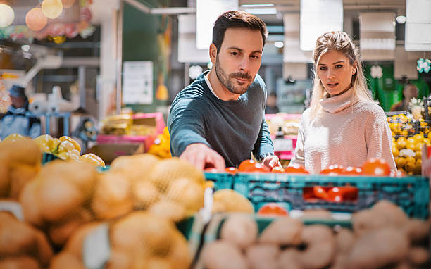 coppia che compra cibo al supermercato locale. - clothing uncertainty household equipment brown hair foto e immagini stock