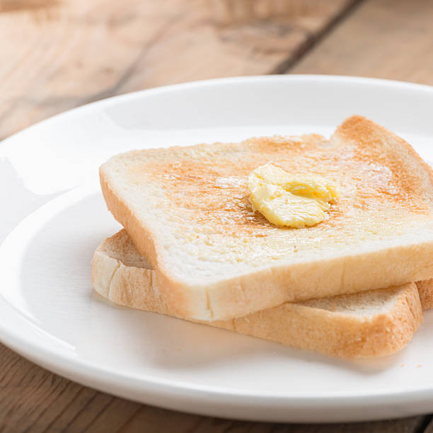 istock Toasted bread with butter on whit plate. 621272098