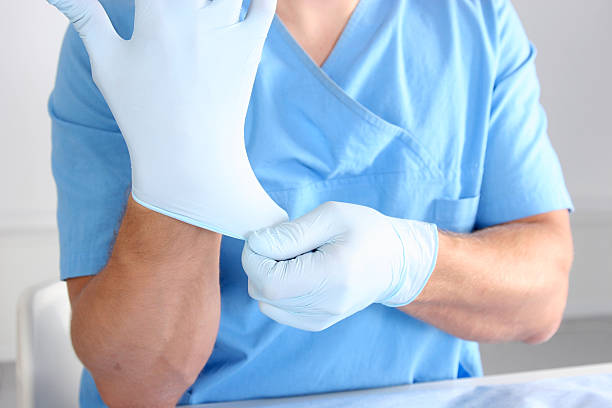 istock Doctor putting on blue sterilized surgical glove 621272942