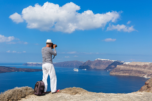 Man photographs the sea and the volcano of Santorini, Greece