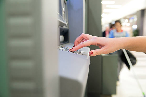 istock Close-up of Woman Using an Automated Teller Machine 621349132
