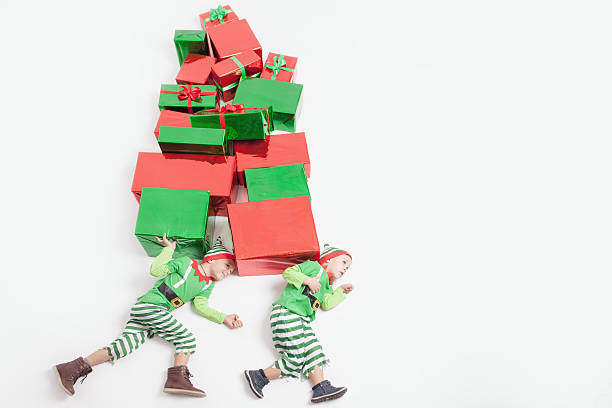 istock Boys dressed Elf costumes holding many gift boxes. Black Friday. 621349916