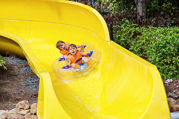 istock excited children in water park riding on slide with float 621350904