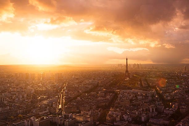 Paris skyline with Eiffel Tower Paris skyline with Eiffel Tower at sunset on a cloudy day. La Defense business district can be seen in the distance behind the tower. outer paris stock pictures, royalty-free photos & images
