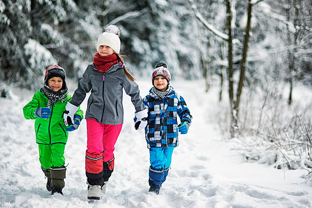 istock Happy children running in winter forest 621352752