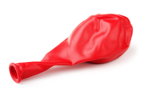 Deflated red rubber balloon isolated on white background
