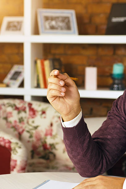 istock Man holding pencil and writing on a paper in the 621352816