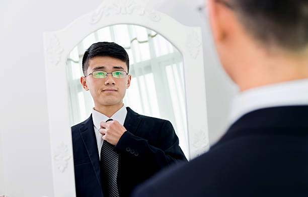 istock Young asian businessman adjusting necktie 621352908