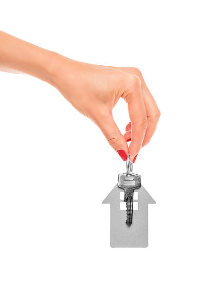 istock Hand holds key with a keychain the shape of house. 621352978