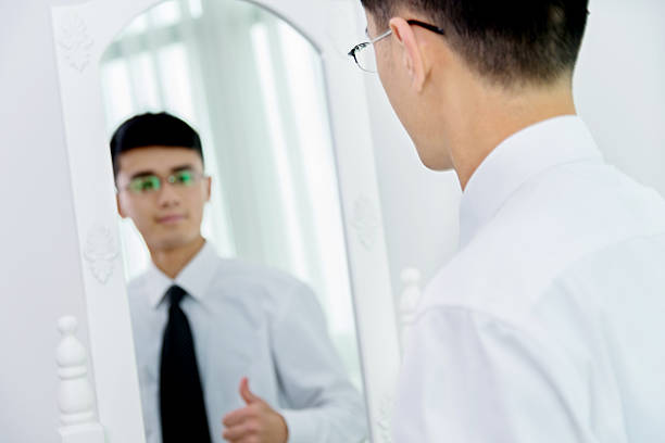 istock Young asian businessman checking his looks 621353148
