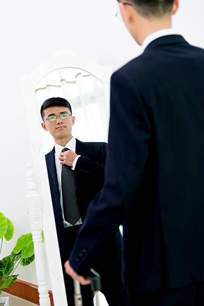 istock Young asian businessman adjusting necktie 621353260
