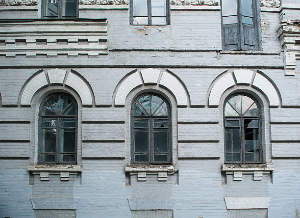 istock Facade of old abandoned building with three large arched windows 621354186