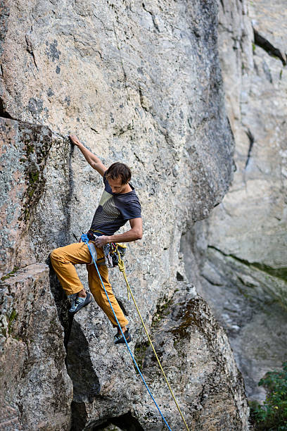 istock Extreme sport climbing.Rock climber ascending a challenging cliff. 621355178