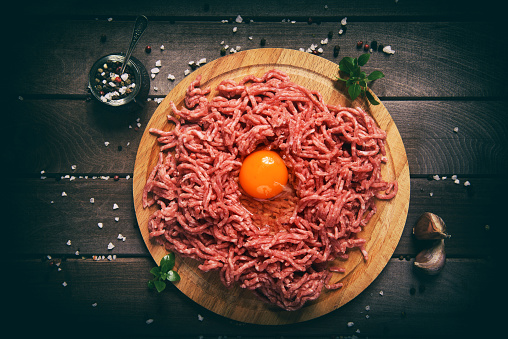 chopped red meat. forcemeat on a wooden background.