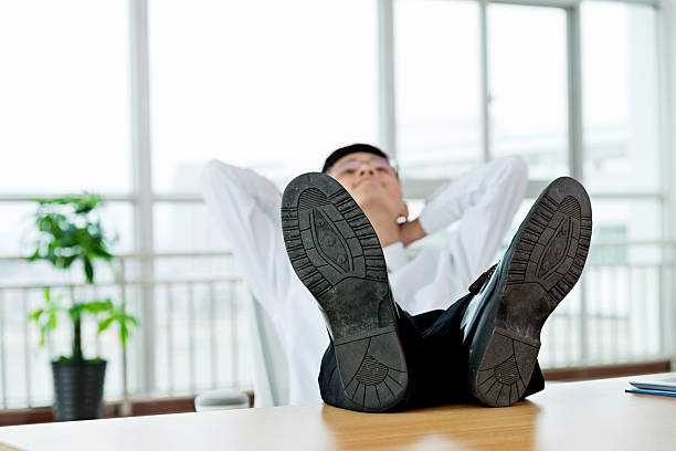 istock Businessman with feet up on desk 621356382