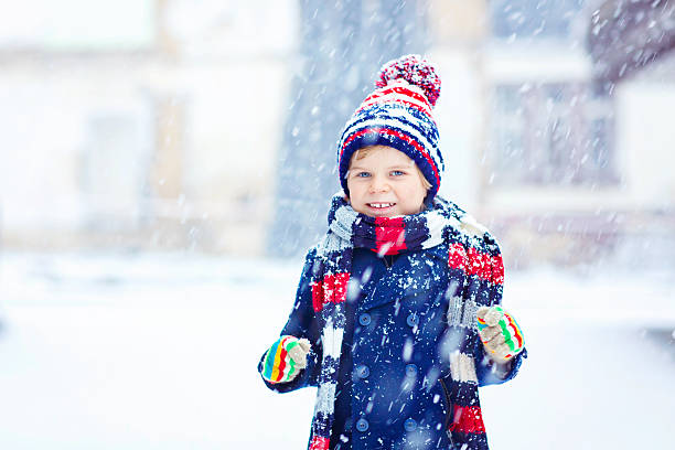istock Happy kid boy having fun with snow in winter 621356444