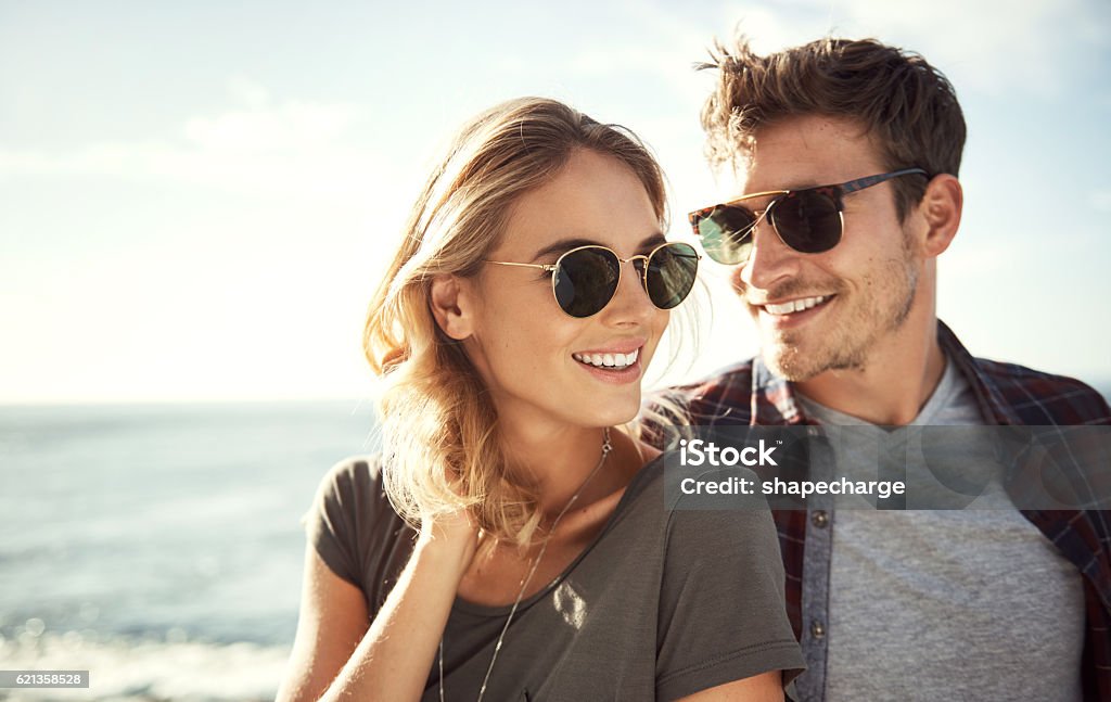 This is the perfect place Shot of an affectionate young couple enjoying a day outdoors Sunglasses Stock Photo