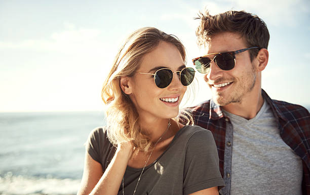This is the perfect place Shot of an affectionate young couple enjoying a day outdoors sunglasses stock pictures, royalty-free photos & images