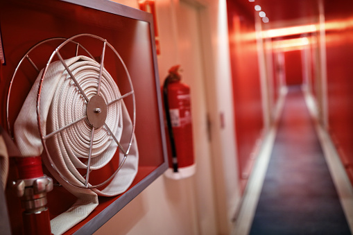 Fire extinguisher and fire hose reel in hotel corridor