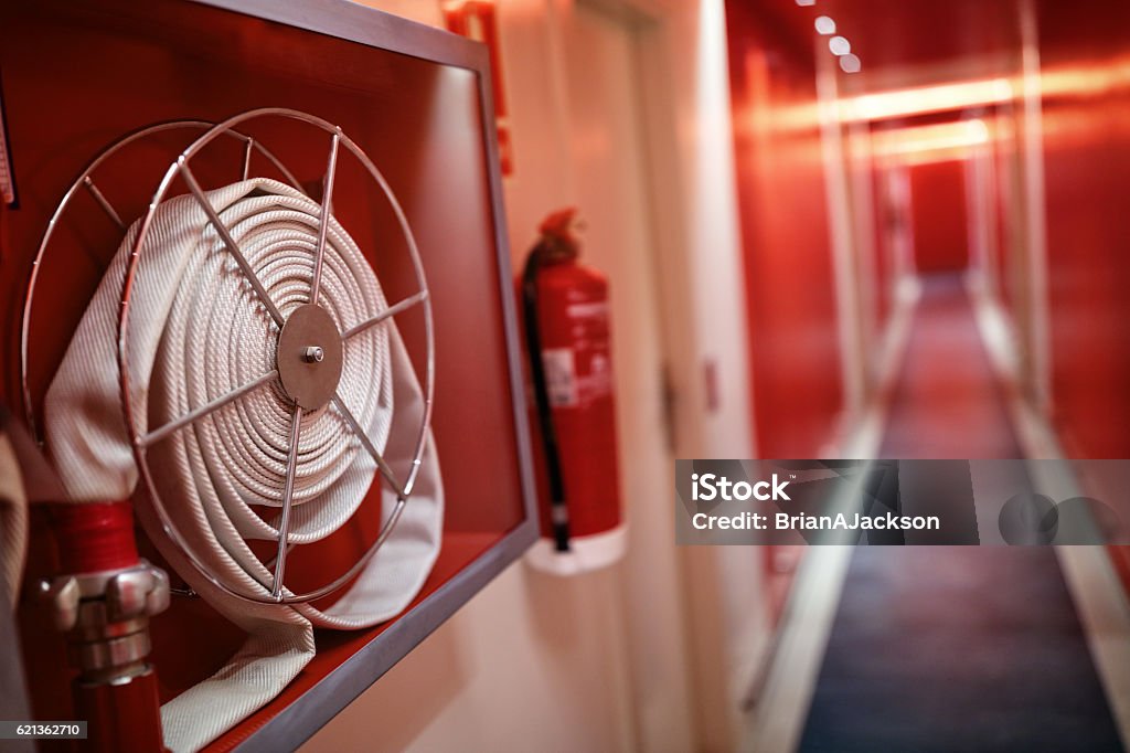 Fire extinguisher and hose reel in hotel corridor Fire extinguisher and fire hose reel in hotel corridor Fire - Natural Phenomenon Stock Photo