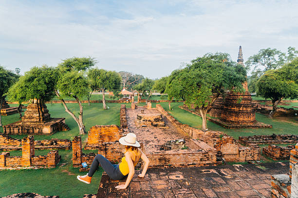 istock Woman sitting and looking at ancient Buddhist Temple 621363042