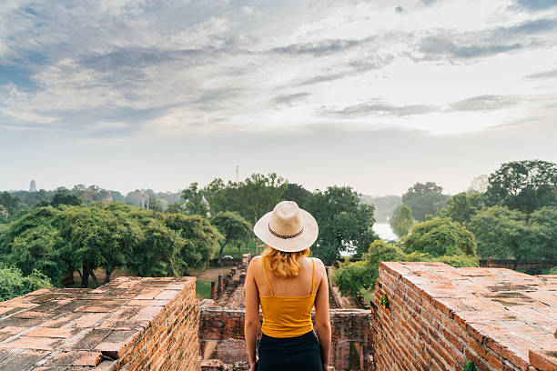 istock Woman looking at ancient Buddhist Temple 621363116