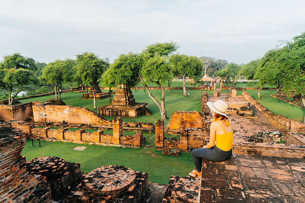 Woman sitting and looking at ancient Buddhist Temple