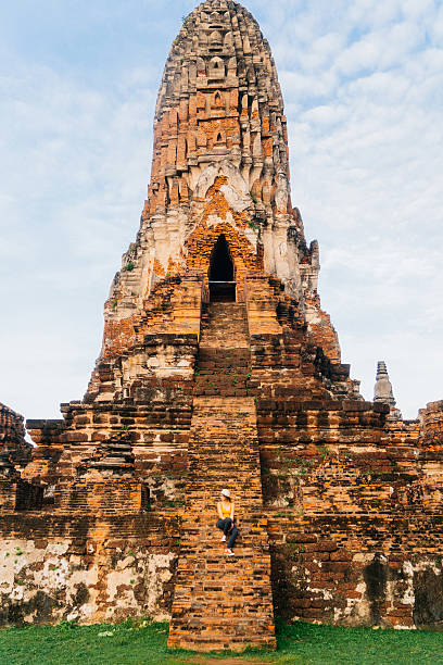 istock Woman sitting near Buddhist Stupa 621363210
