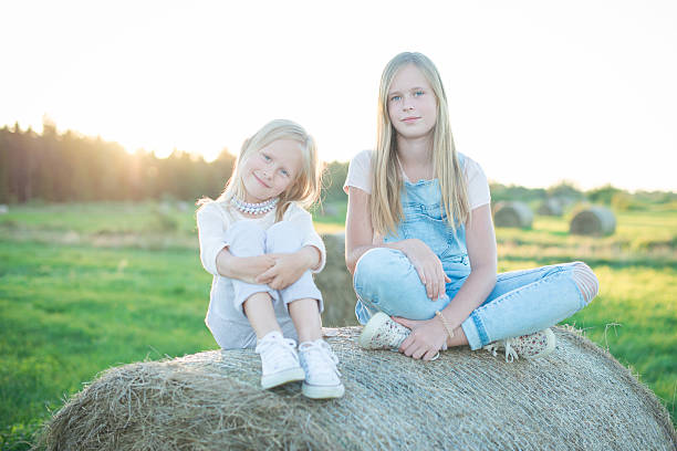 istock Beautiful young girls sitting on the haystack 621364142